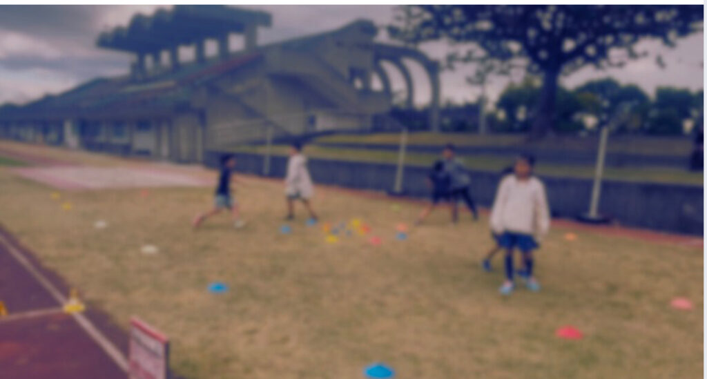 西原町西原運動公園陸上競技場の芝生でトレーニング